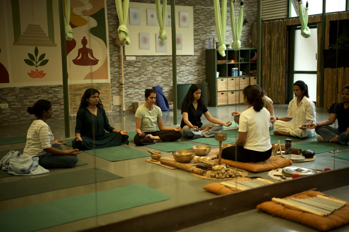 A small circle of women meditating together around singing bowls at The Sphere