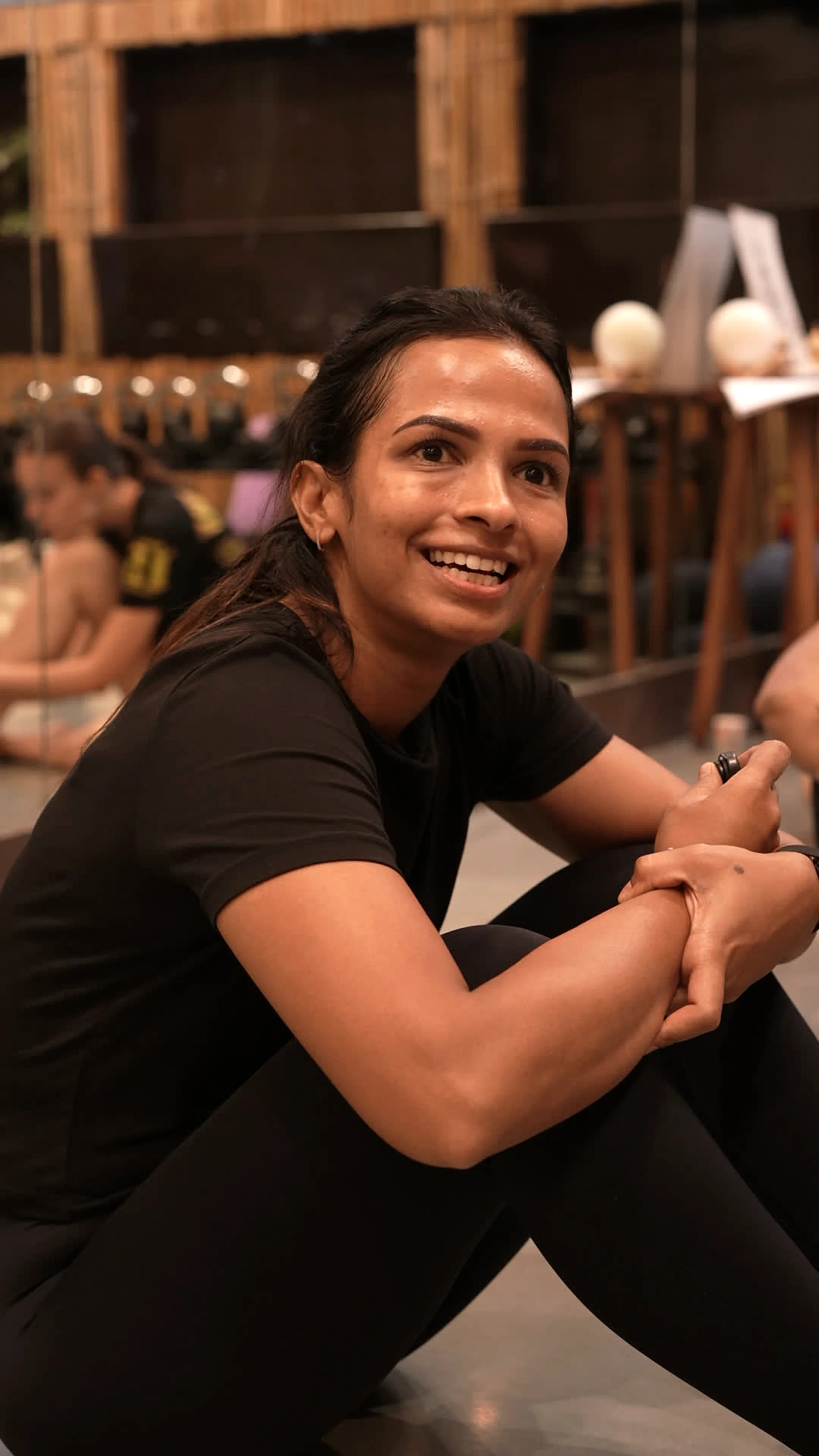A member smiling, seated on the studio floor at The Sphere